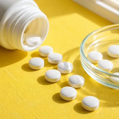 White Vitamins on Yellow Wellness Tabletop