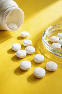 White Vitamins on Bright Yellow Tabletop