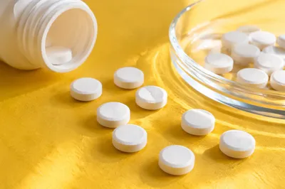 White Vitamins on Bright Yellow Tabletop