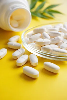 White Vitamins on Bright Yellow Tabletop
